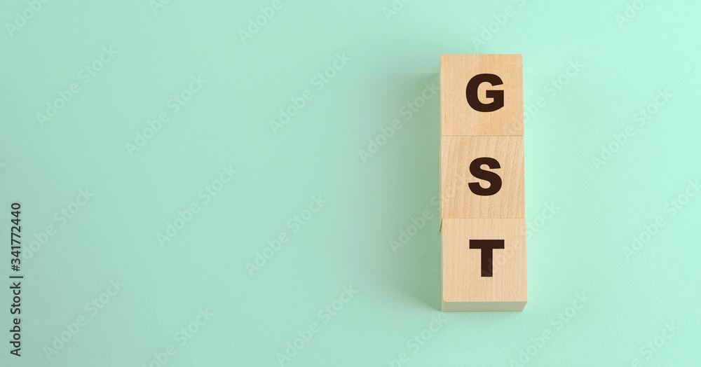 abbreviation gst inscription on wooden blocks isolated on blue background