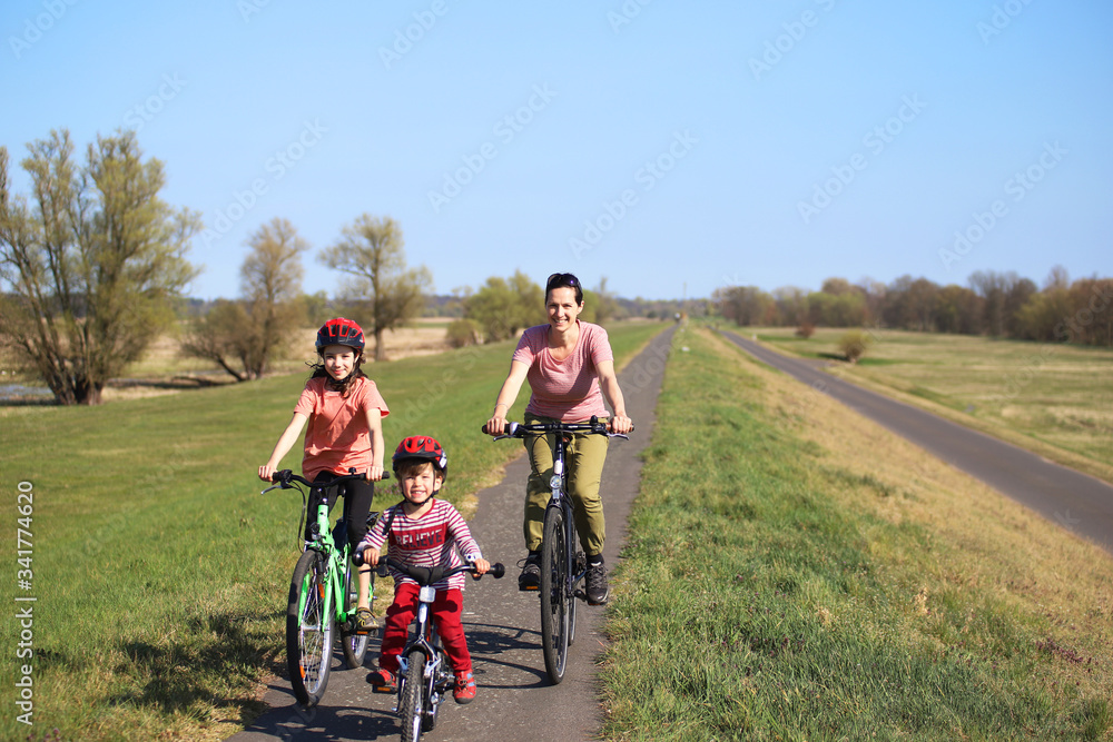 Eine Frau macht mit ihren Kindern eine Radtour auf dem Oderdamm während der Corona-Krise am 13.04.2020.