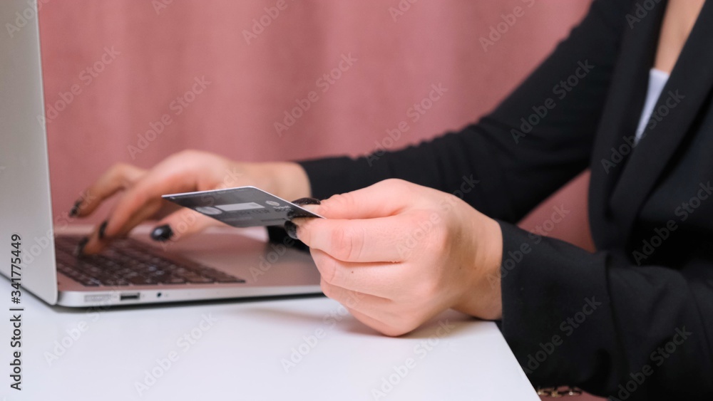 female hands make a purchase on the Internet using a laptop, payment by card, close-up. female hands make a purchase on the Internet using a laptop, payment by card, close-up.