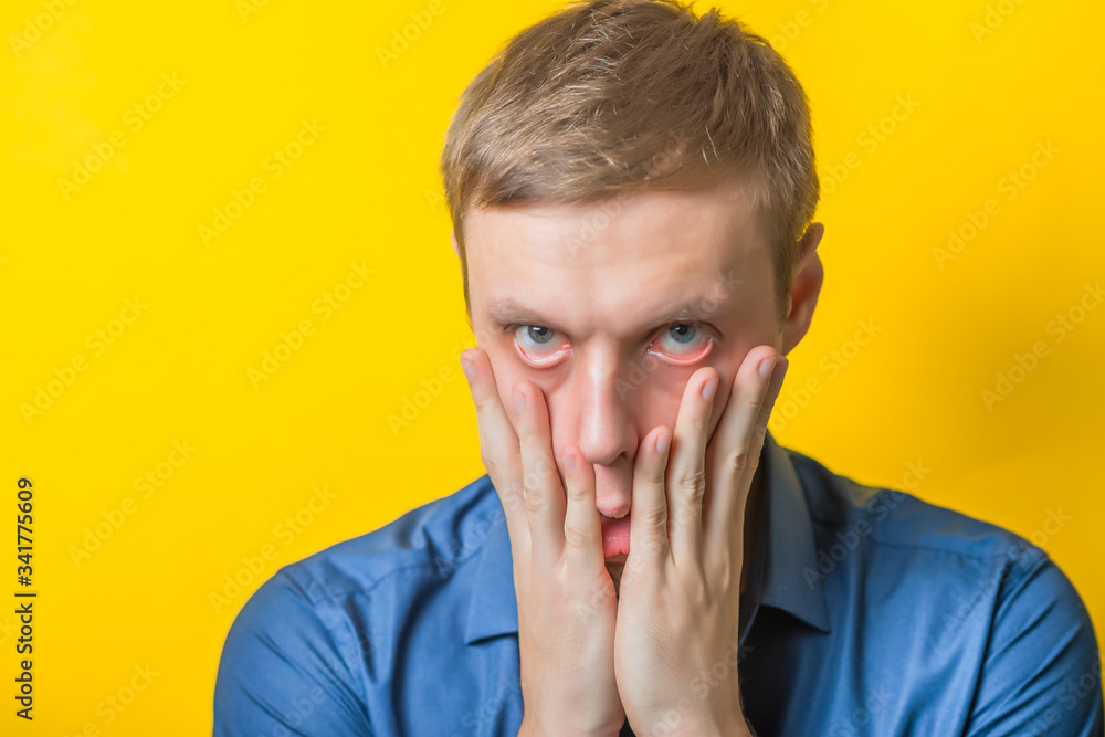 Blond young man shocked tired. Gesture. Close portrait. Isolated yellow background. photo Blond young man shocked tired. Gesture. Close portrait. Isolated yellow background. photo