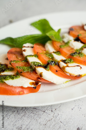 caprese with tomato slices and herbs served with pesto