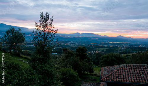 An aerial view of the city of Quito nestled in the valley at sunset, from one of the surrounding hills, with the airport in the distance