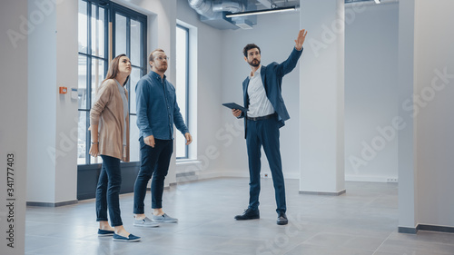 Konstfotografi Real Estate Agent Showing a New Empty Office Space to Young Male and Female Hipsters