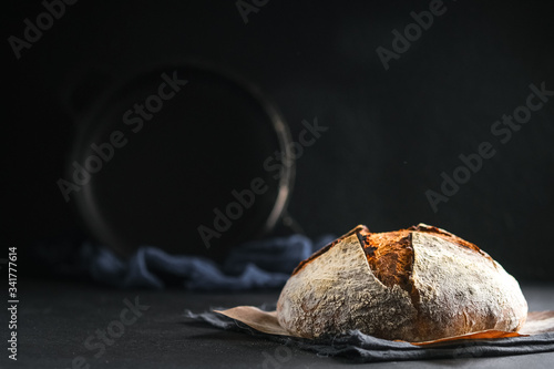 .Bread. Homemade whole grain bread on a dark napkin on a dark background copy space.