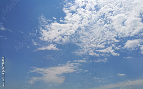 Fototapeta Naklejka Na Ścianę i Meble -  Look up  bright blue sky background with tiny clouds.