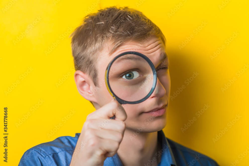 Man looking through a magnifying glass Man looking through a magnifying glass
