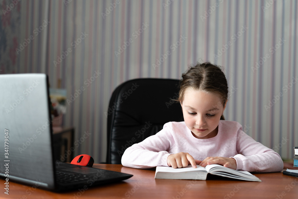 little girl first grade student. Learning at home. Distance education during a pandemic. Independent work. little girl first grade student. Learning at home. Distance education during a pandemic. Independent work.