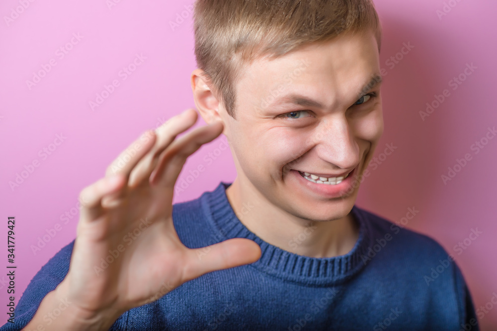 Young man scared smiling, joking. Gesture. On a purple background. Young man scared smiling, joking. Gesture. On a purple background.