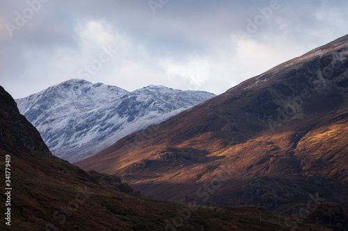 Autumn landscape in Highlands, Scotland, United Kingdom. Beautiful mountains with snow in background.