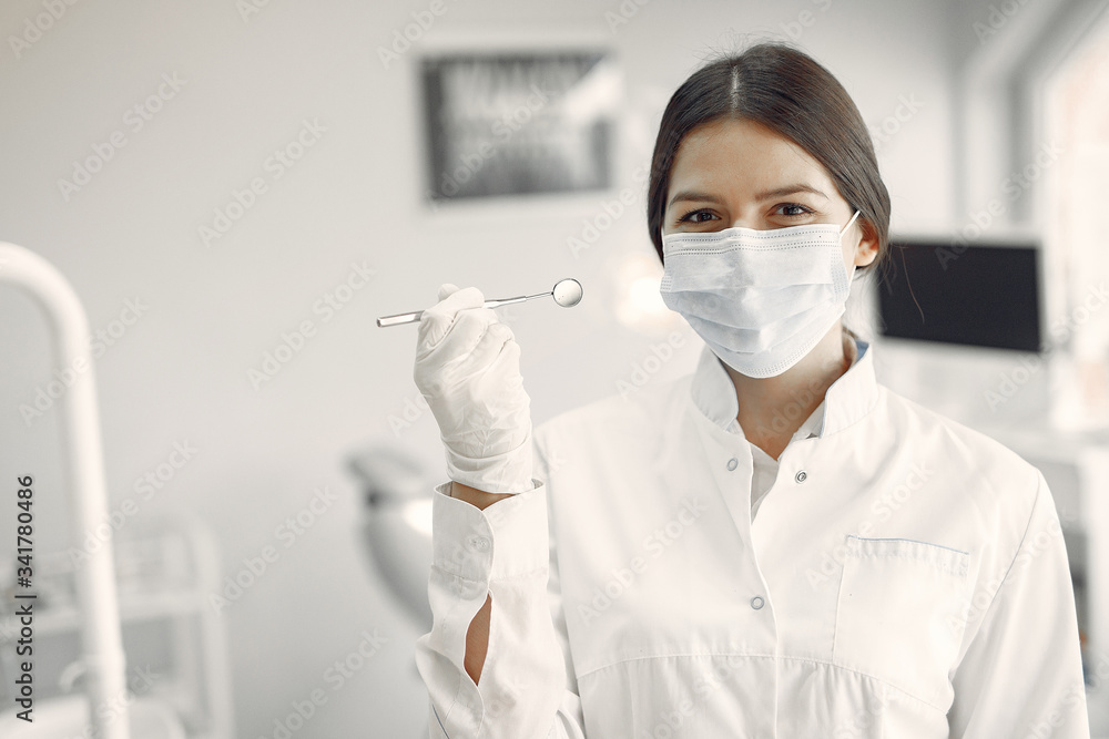 Woman in a uniform. Doctor working at the clinic. Dentist holds a tools in her hands Woman in a uniform. Doctor working at the clinic. Dentist holds a tools in her hands