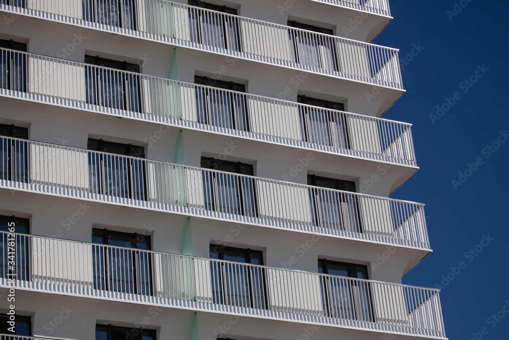 white building with a lot of windows and balconies white building with a lot of windows and balconies