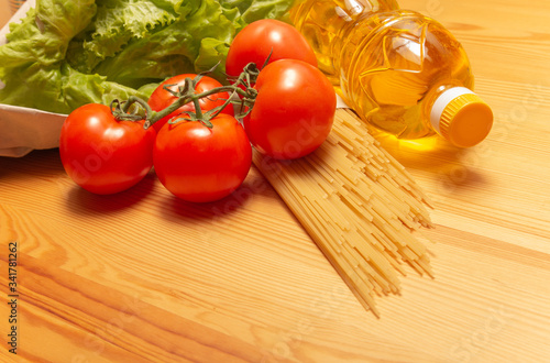 Food delivery service. Healthy food on wooden table. Buy online during quarantine. Tomatos, pasta, sunflower oil, salad. High quality photo. Stay home, be safe.