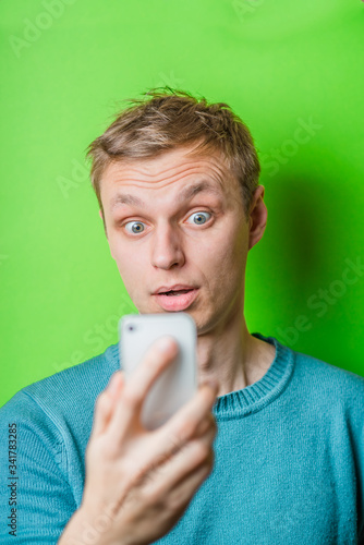 Wallpaper Mural A confused young man looking at mobile phone Torontodigital.ca