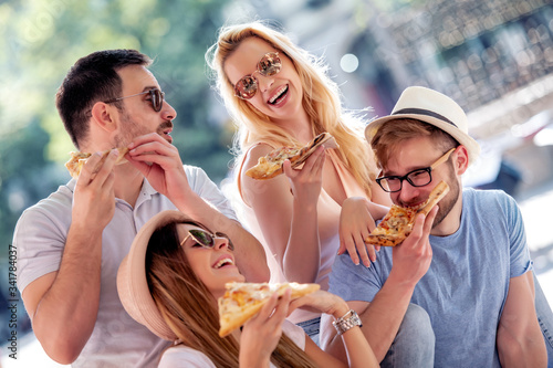 Cheerful friends eat pizza together.