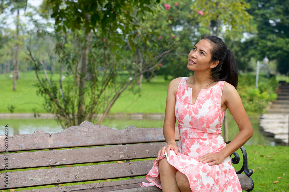 Fototapeta premium Happy mature Asian woman relaxing at the park outdoors