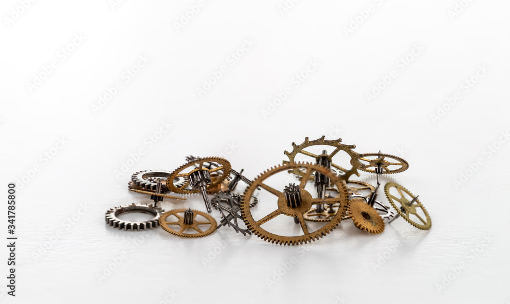 A bunch yellow metal gears of various sizes on a white background. A bunch yellow metal gears of various sizes on a white background.