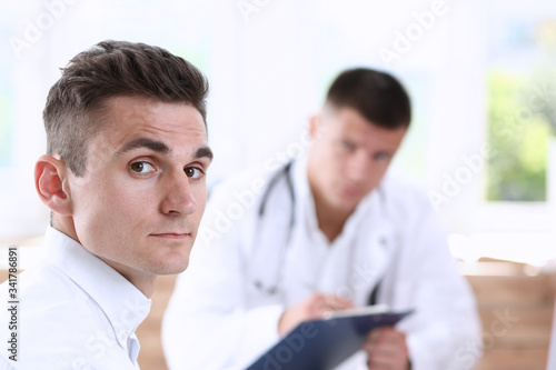 Satisfied happy handsome smiling male patient with doctor at his office. High level and quality medical service, therapeutist consultation, work and career, physical, healthy lifestyle concept