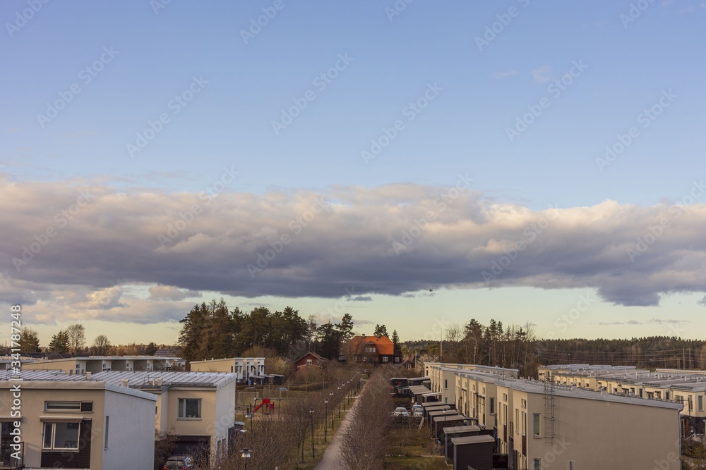 Fototapeta premium Beautiful landscape view over light yellow townhouses on gorgeous blue sky with white clouds background .Beautiful cityscape background. Europe. Sweden. Uppsala. 