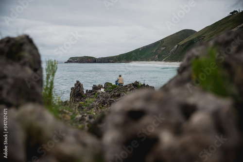 Un hombre pescando un día nublado en la Playa de San Antolin en Asturas, España. Playa rocosa en el mar Cantábrico. photo