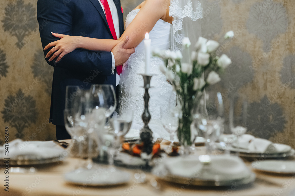 The bride and groom are hugging in a romantic setting in a beautiful interior. Photography, concept. The bride and groom are hugging in a romantic setting in a beautiful interior. Photography, concept.