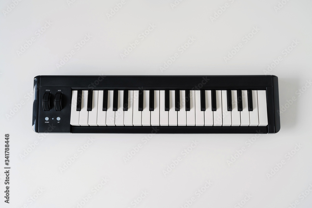 Close up of home synthesizer on a white table. Piano keyboard. Close up of home synthesizer on a white table. Piano keyboard.