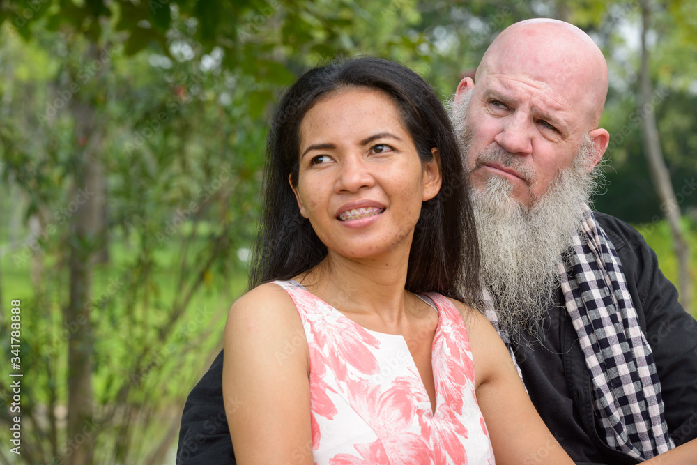 Happy mature multi ethnic couple together and in love at the park outdoors Happy mature multi ethnic couple together and in love at the park outdoors