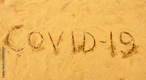 Inscription on the sand covid-19