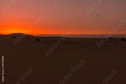 colorful sunset over desert sand dunes