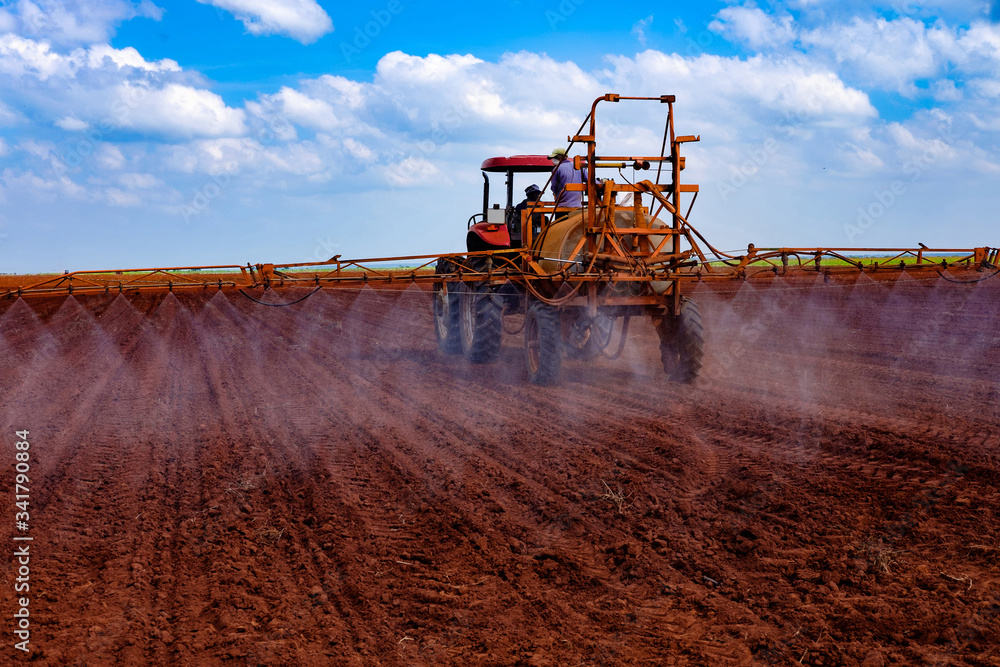 Fototapeta premium Tractor spraying the lands for weeds