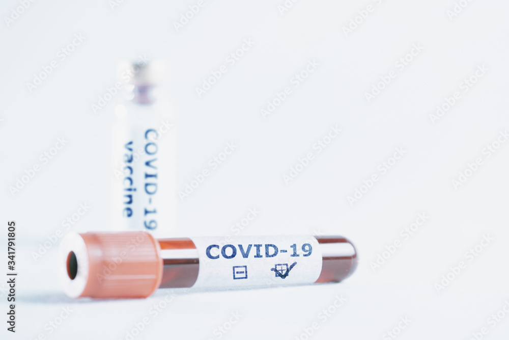 Test tube with positive covid-19 blood sample and bottle with vaccine.