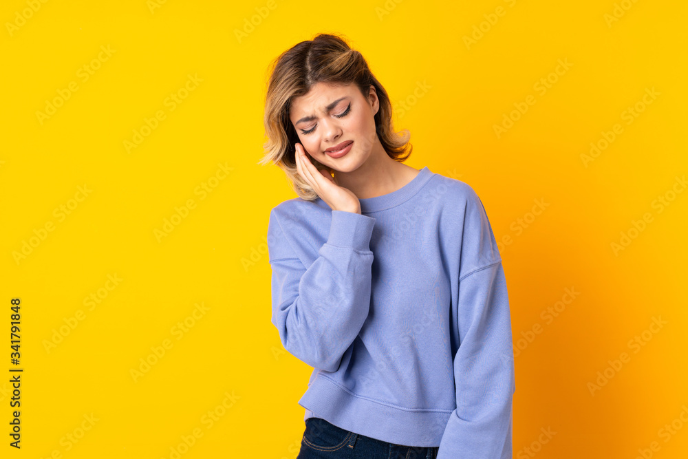 Young Russian woman isolated on yellow background with toothache Young Russian woman isolated on yellow background with toothache