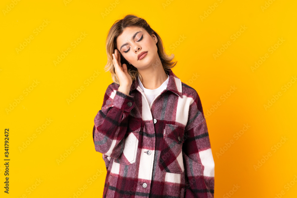Young Russian woman isolated on yellow background with headache Young Russian woman isolated on yellow background with headache