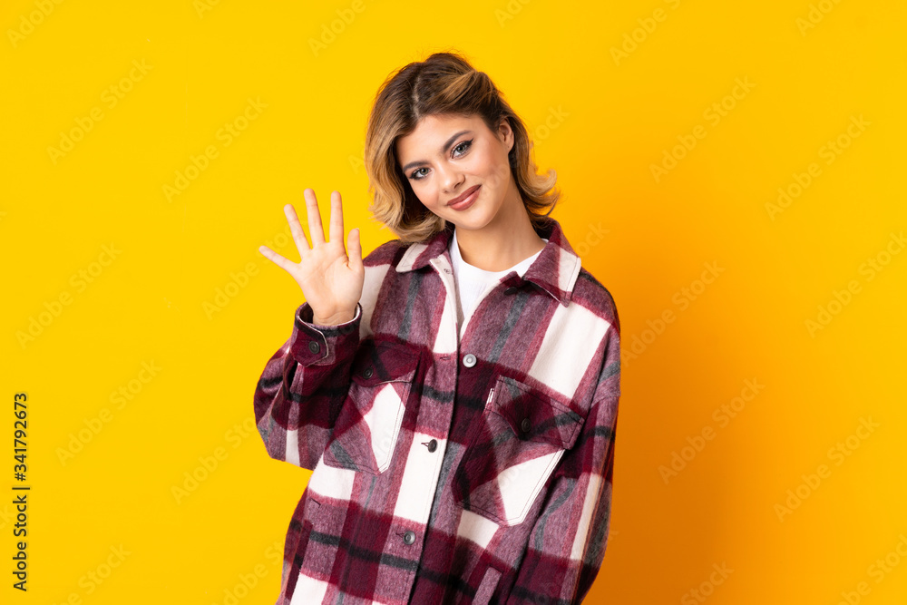 Young Russian woman isolated on yellow background saluting with hand with happy expression Young Russian woman isolated on yellow background saluting with hand with happy expression