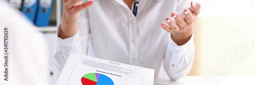 Business woman explains employee financial statistics on an example of a schedule with an indication of reporting for the annual period of the hand gesture is clear to all arm teamwork