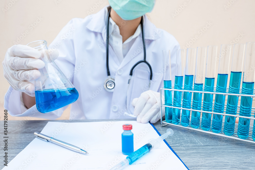 The doctor is experimenting with the blue serum liquid with scientific equipment The doctor is experimenting with the blue serum liquid with scientific equipment