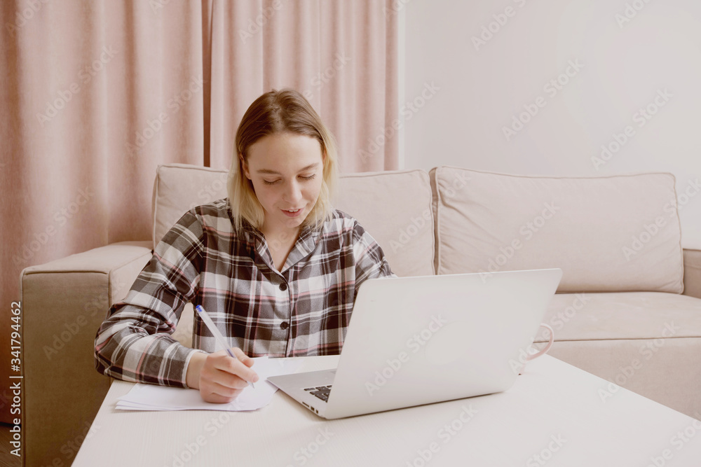 Young beautiful girl in checkered pajamas outlines a lecture. Young beautiful girl in checkered pajamas outlines a lecture.