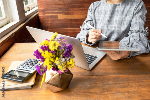 Business woman working at home with her laptop and tablat photo