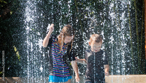 Young Boy and Girl Dancing at Splash Pad, Houston, Texas , USA photo
