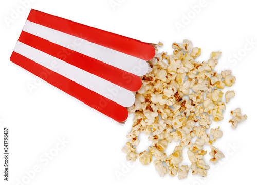 Overturned red striped paper popcorn bucket and delicious popcorn near isolated on white background.