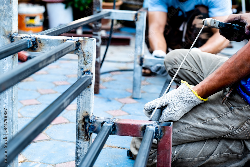 The mechanic is using a welding machine to weld steel The mechanic is using a welding machine to weld steel