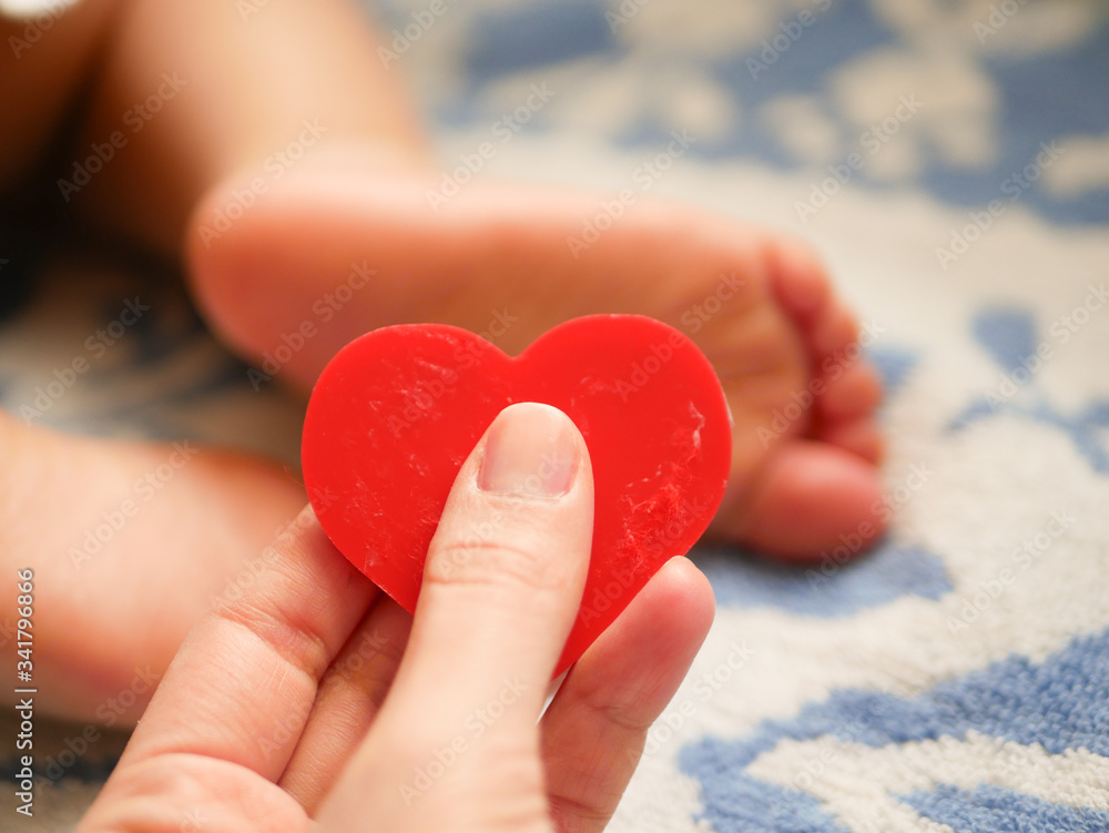 mother holds heart on the background of a small child mother holds heart on the background of a small child