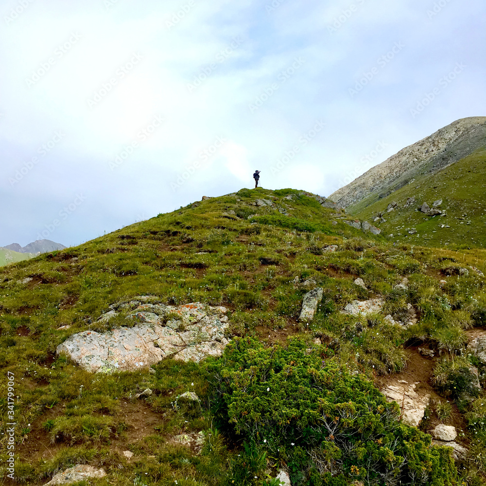 Fototapeta premium Mountain landscape with a silhouette of a man on top of a mountain. There is a place for inscription.