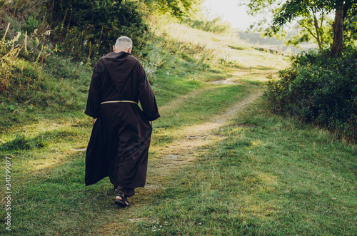 фотографія a Catholic  monk in robes praying in the woods. Copy space