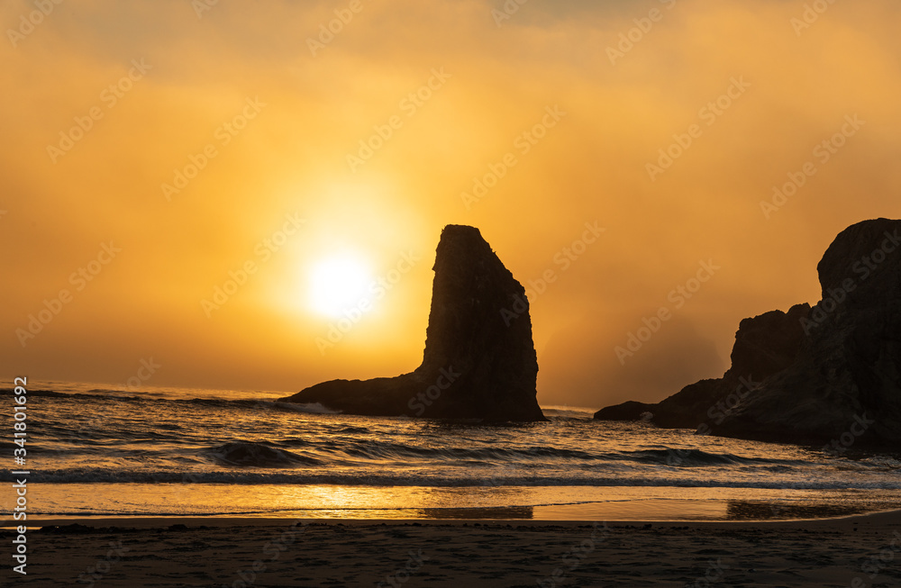 Orange Sunset silhouettes sea stacks on Bandon Beach in Oregon