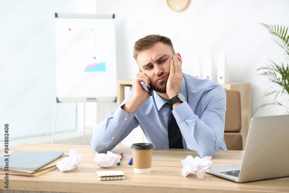 Lazy office employee talking on phone at workplace Lazy office employee talking on phone at workplace