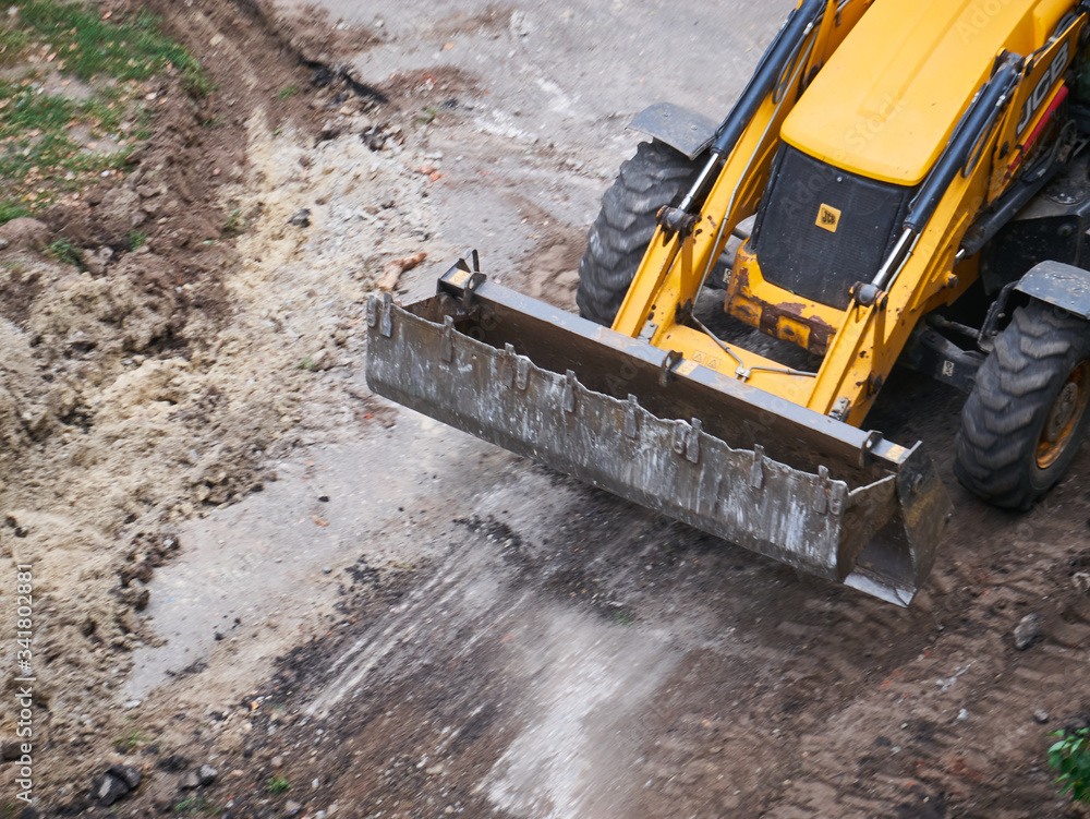 Hydraulic Excavator Removing Remains of asphalt. Road reconstruction. Pavement repair