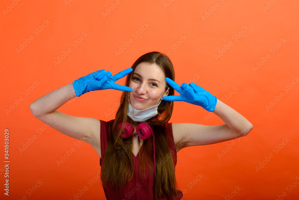 Girl in protective medical mask and blue gloves on red background. close-up portrait of a woman in a transparent mask. way to protect against coronavirus. Covid-2019, Pandemic 2020 Girl in protective medical mask and blue gloves on red background. close-up portrait of a woman in a transparent mask. way to protect against coronavirus. Covid-2019, Pandemic 2020