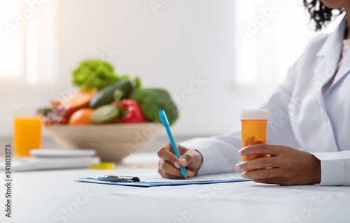 Cropped of black woman doctor dietologist prescribing pills