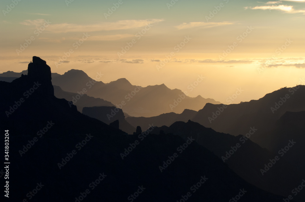 Roque Bentaiga to the left and cliffs of the west of Gran Canaria at sunset. Gran Canaria. Canary Islands. Spain.