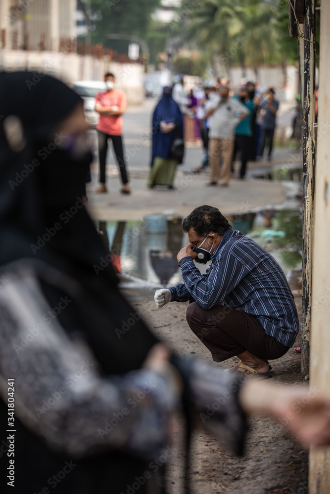 People wait for hours in long queues for Covid-19 tests at BSMMU fever clinic near Shahabagh in the capital of Bangladesh ,Monday morning on April 20,2020. Photo:Saikat Bhadra